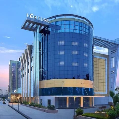 Durable campus-style arrival landscaping with structured planting beds and approach paving.